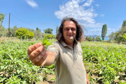 Nikos pokazujący plony w ogrodzie w Grecji